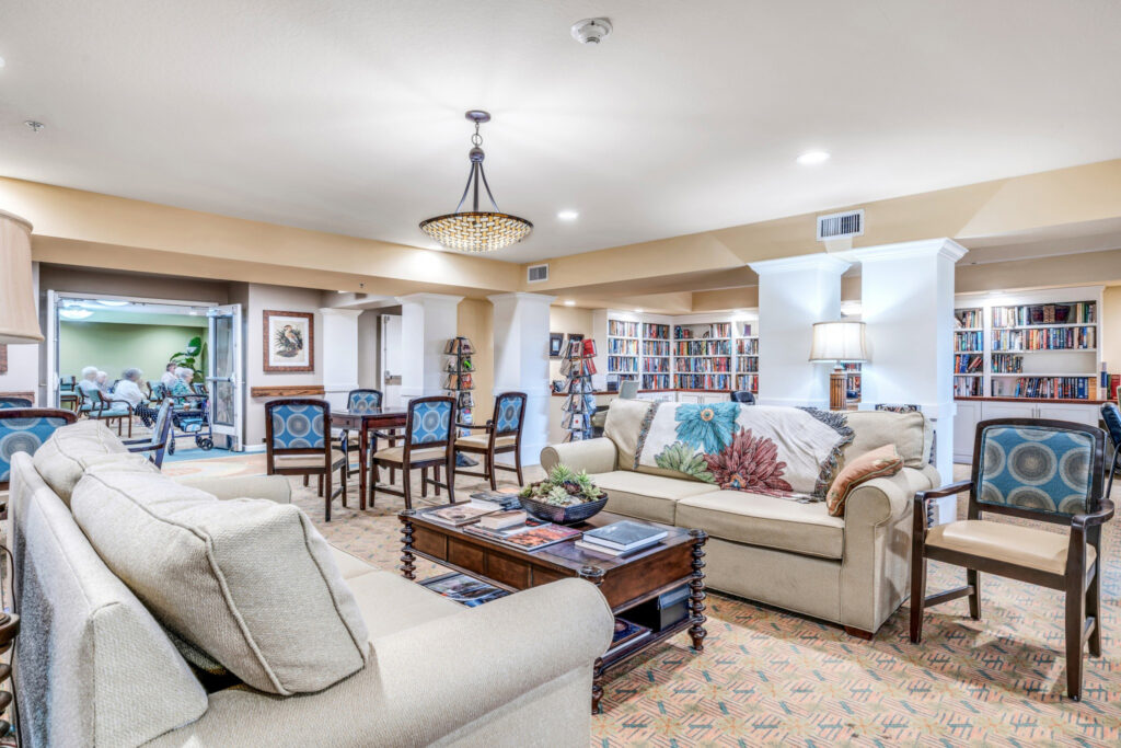 Interior image of Camellia at Deerwood common area with book cases, games, and comfortable couches for relaxing.