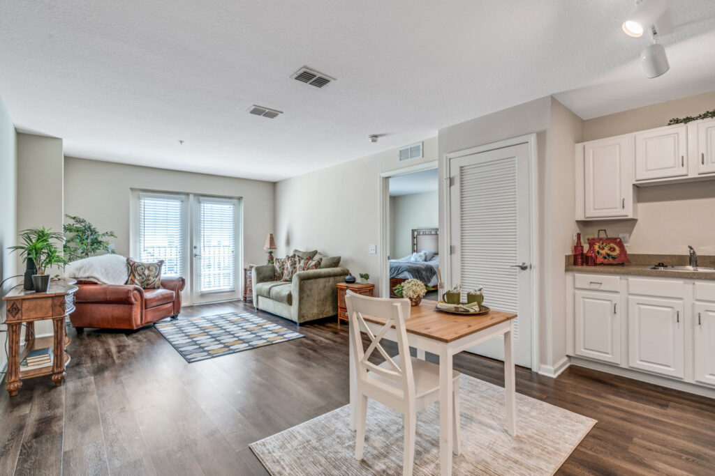 Interior image of a resident's combined kitchen and living room at Camellia at Deerwood.