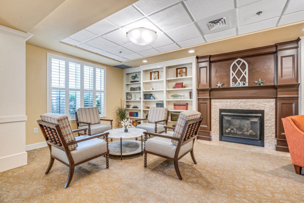 Interior image of Camellia at Deerwood common area with fire place, book cases, and comfortable chairs for relaxing in Florida.